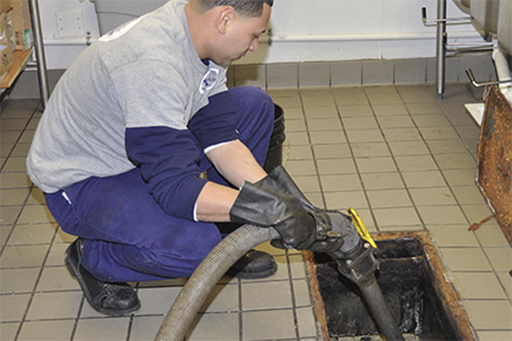 man working on grease traps