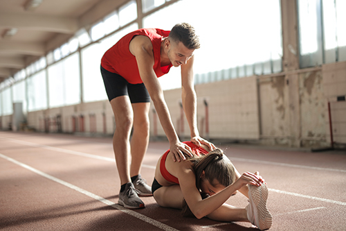 Trainer helping client stretch