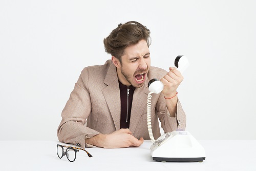 An irate man yelling into a phone