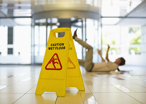 wet-floor-sign Businessman slipping on wet office floor