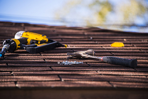 Roofing-Equipment Roof shingle repair with nail gun and hummer