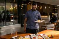 A restaurant owner introducing a few of his dishes