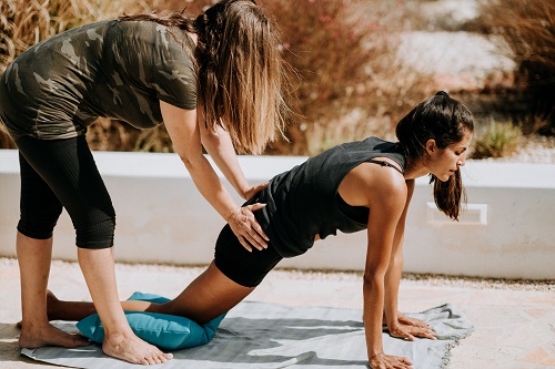 A yoga instructor helping a participant