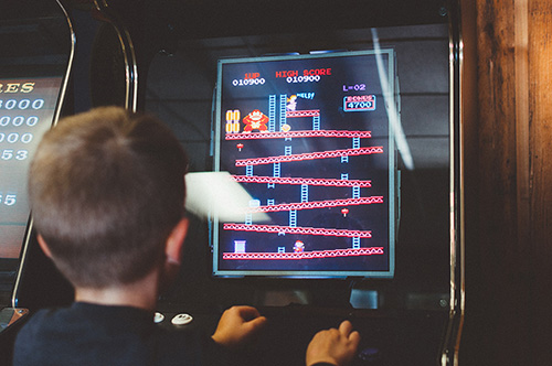 kid playing retro arcade game
