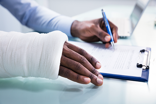 An injured worker filling out a compensation form.