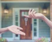 A landlord passing the key to a rental property to a tenant.