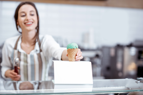 An ice cream shop owner serving up a tasty treat.