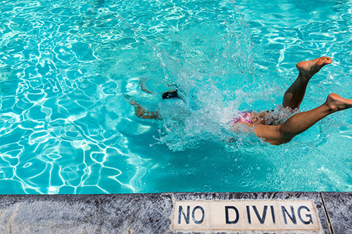 person slipping into a pool